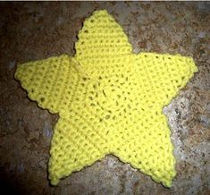 a crocheted yellow star is laying on the ground