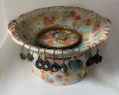 a bowl with rings and charms on it