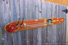 a skateboard mounted to a wooden fence with red spokes and wheels on it