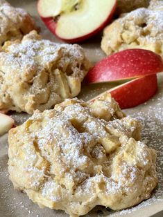 apples and powdered sugar cookies are sitting on a baking sheet next to an apple