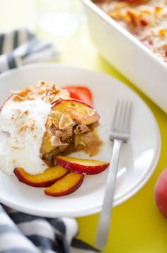 a white plate topped with fruit covered in ice cream next to a casserole dish