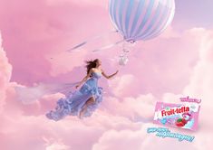 a woman flying through the air with a hot air balloon in her hand and an ad for fruit - gela