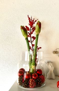 two vases with flowers in them on a table next to other items and decorations