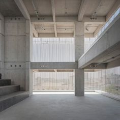 an empty room with concrete walls and stairs