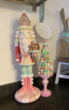 a nutcracker is standing next to a christmas tree on a counter top in a kitchen