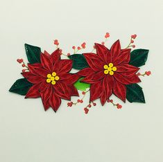 two red poinsettis with green leaves on white background, cut out from paper