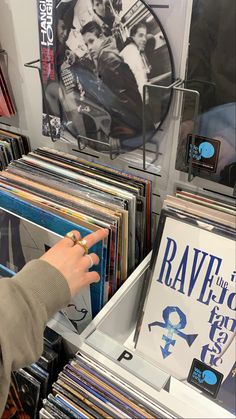 a person is pointing at some records on display