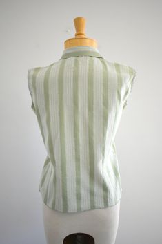 "Description: 1950s/60s green and white striped blouse. Cotton. Ruffled front button placket. Sleeveless. Condition: In great condition, with no holes or stains. Designer: Ship 'n Shore Stated size: 30 Measurements: Armpit to armpit: 18\" Overall length: 20\" Waist: up to 31\" Armhole circumference: 12\" ---> If you need an order shipped by a particular date or shipped via a quicker method, please ask PRIOR to purchase to see if we can accommodate that request. Visit the rest of our shop for Vintage Collared Top With Vertical Stripes, Vintage Collared Tops With Vertical Stripes, Retro Green Cotton Blouse, Green Top With Striped Collar For Work, Green Tops With Striped Collar For Work, Vintage Vertical Striped Summer Tops, Vintage Vertical Striped Tops For Summer, Vintage Green Collared Blouse, Vintage Vertical Stripes Tops For Summer