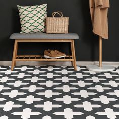 a black and white tiled floor with a bench, coat rack, shoes and basket