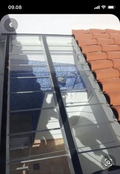 an orange tiled roof with a clear glass window