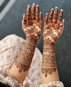 a woman's hands with henna tattoos on them