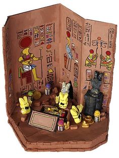 an open cardboard box with various items inside it, including figurines and pictures on the walls