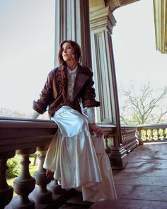 a woman sitting on top of a wooden bench