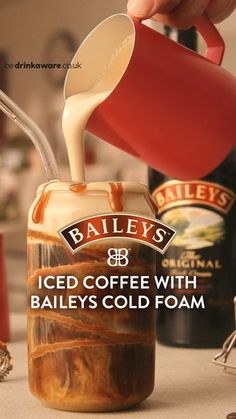 bailey's iced coffee with baileys cold foam is being poured into a jar