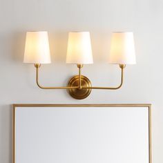 a bathroom light with three lamps on it and a mirror in front of the wall