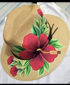 a hat with red flowers painted on it