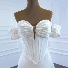 the back of a white wedding dress on a mannequin