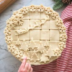 a person holding a pie crust with christmas decorations on it