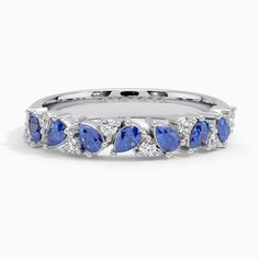 a white gold ring with pear shaped blue sapphires and diamonds on the sides, set in