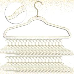 a white hanger with gold glitters on it next to a pile of clothes