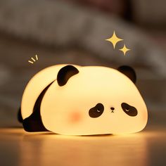 a panda bear lamp sitting on top of a wooden table next to a star shaped light