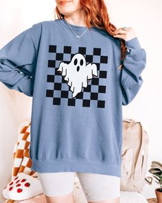 Checkered Ghost Sweatshirt. These sweatshirts are Comfort Colors. The comfort and style are what this unisex, garment-dyed sweatshirt is all about. It's made with 80% ring-spun cotton and 20% polyester and the fabric is 3-end garment-dyed, ring-spun, color-blast fleece with a 100% cotton face. Each sweatshirt comes with a relaxed fit, a rolled-forward shoulder, and a back neck patch.  ✦ 80% Ring-Spun Cotton, 20% Polyester ✦ Color: Pepper, White, Chambray, Butter, Light Green, Blue Spruce, Blue jean, Orchid ✦ Relaxed fit ✦ Medium-heavy fabric ✦ Sewn-in twill label ✦ Eco-friendly, Ethically Made & Sweatshop Free ✦ Printed to order with non-toxic ink ✦ Durable and Long-lasting ✦ Shirts are pre-shrunk but may shrink slightly after washing ✦ Made to order: *Please allow 2-5 business days to pri Halloween Streetwear Sweatshirt With Relaxed Fit, Halloween Streetwear Crew Tops, Spooky Graphic Print Sweatshirt For Streetwear, Halloween Cotton Sweatshirt With Graphic Print, Halloween Graphic Print Cotton Sweatshirt, Halloween Band Merch Sweatshirt With Screen Print, Halloween Band Merch Long Sleeve Sweatshirt, Halloween Graphic Print Casual Sweatshirt, Halloween Crew Neck Sweatshirt With Screen Print