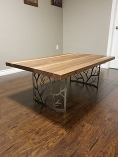 a wooden table sitting on top of a hard wood floor next to a white wall