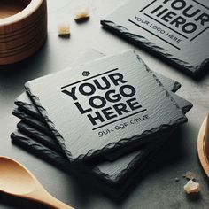 four slate coasters with the words your logo here on them and spoons next to them