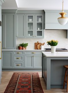 a kitchen with blue cabinets and an area rug on the floor in front of it