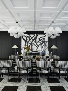 the dining room is decorated in black and white striped chairs, with chandeliers hanging from the ceiling