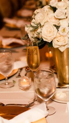 there is a vase filled with white flowers on the table at this wedding reception,