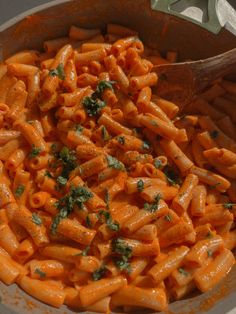 a pot filled with pasta and parsley on top of a table