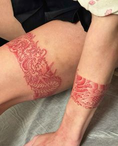 a woman's legs with red tattoos on them