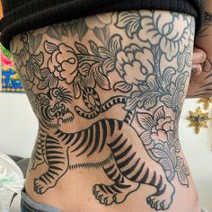 a woman with a tiger tattoo on her lower back and the upper part of her stomach