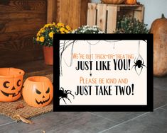 two pumpkins sitting on the floor next to a sign that says, we're out trick - or - treat just like you? please be kind and just take two