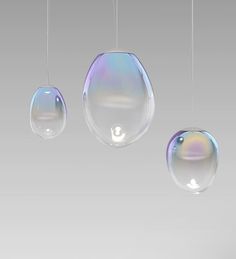 three bubbles hanging from strings in front of a gray background with white and blue colors