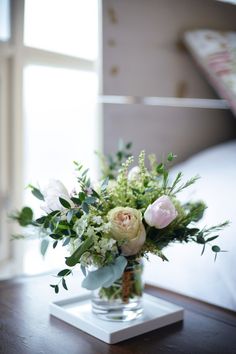 a vase filled with flowers on top of a wooden table