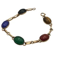 This Vintage Symmetallic Bracelet Features Intricately Carved Scarabs Set In Sterling Silver With 14k Gold Vermeil Accents. Each Scarab, Crafted From Vibrant, Colored Stones, Adds A Touch Of Elegance And Historical Significance. The Bracelet's Classic Design Is A Nod To Ancient Egyptian Artistry, Making It A Timeless Piece For Collectors. Intricate Scarab Design Sterling Silver & 14k Gold Colored Stone Scarabs Classic Clasp Closure 7.25 Inches Length Bracelet Measures 7.25 Inches In Length. Nice Estate Condition Width: Approx. 3/8 " Cabochons Features: Made In Usa Size: Womens 7 1/4 Inch Condition: Pre-Owned Good Nice Estate Condition Scarab Bracelet, Colored Stones, Colored Stone, Gold Overlay, Ancient Egyptian, Womens Jewelry Bracelets, Timeless Pieces, Gold Vermeil, Stone Color