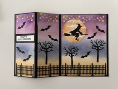 an open halloween card with bats and a full moon in the sky, on top of a fence