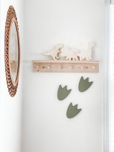 there is a wooden dinosaur on the wall next to a mirror and coat rack with hooks