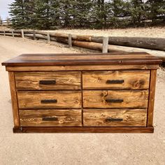 a wooden dresser sitting on top of a dirt road