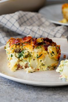 a white plate topped with a piece of quiche next to a knife and fork