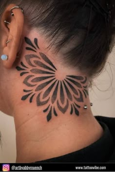 a woman's neck with a tattoo design on it