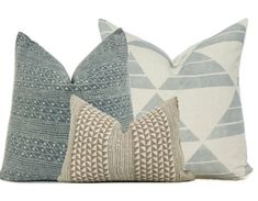 three pillows with different patterns on them, one in blue and the other in beige