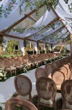 rows of chairs are lined up under a tent