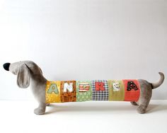 a toy dachshund dog is wearing a colorful sweater with letters on it