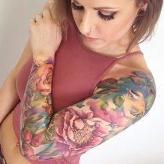 a woman with tattoos on her arm and arms is looking down at the viewer's phone