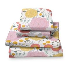 three sheets with flowers on them and one has pink, yellow and green leaves in the middle