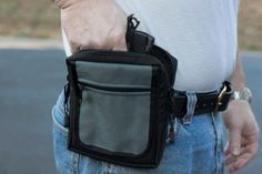 a man wearing a white t - shirt is holding a black bag in his left hand