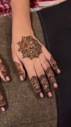 a woman's hand with henna tattoos on it